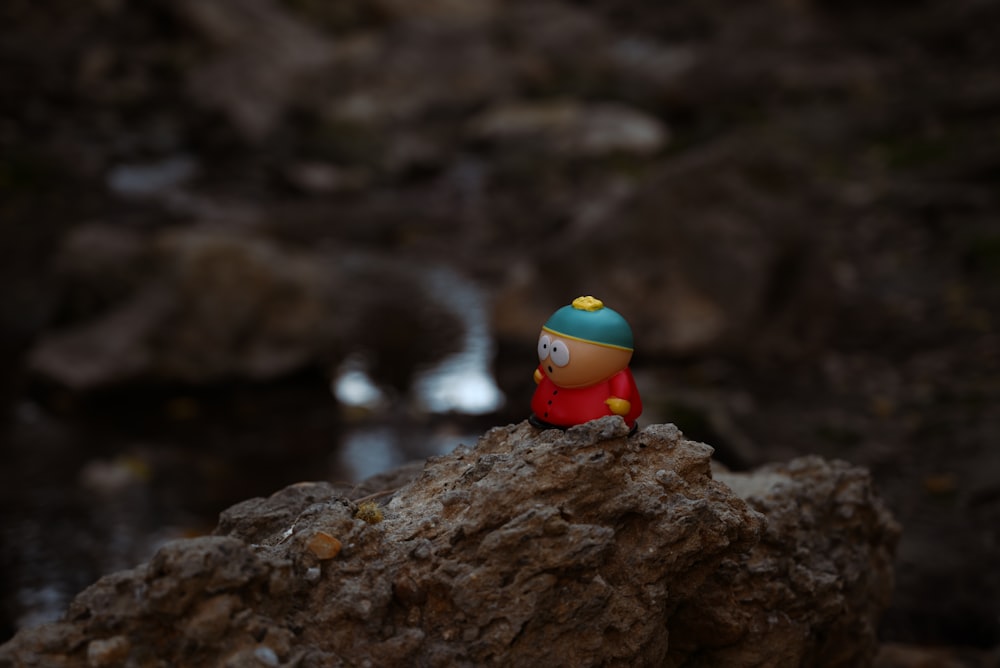 a small toy sitting on top of a rock
