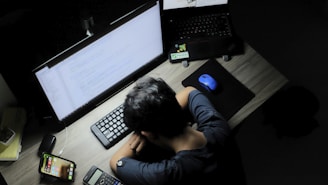 a man sitting in front of a computer monitor
