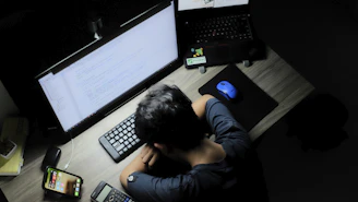 a man sitting in front of a computer monitor