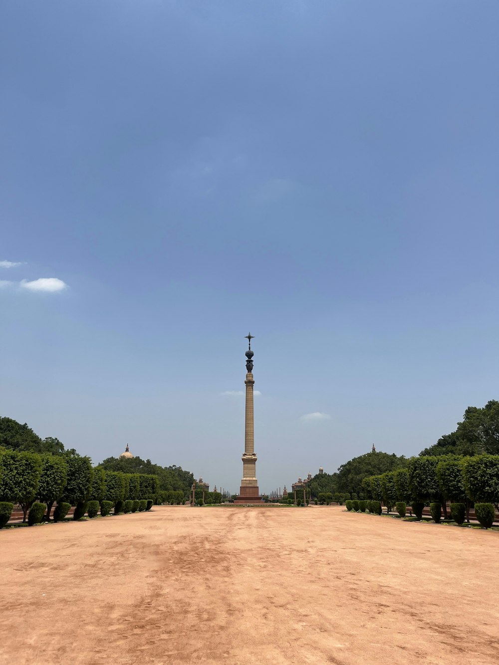 a dirt road with a monument in the middle of it