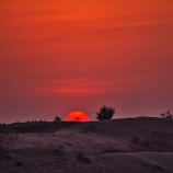 A vibrant sunset over the sandy dunes of the Thar Desert