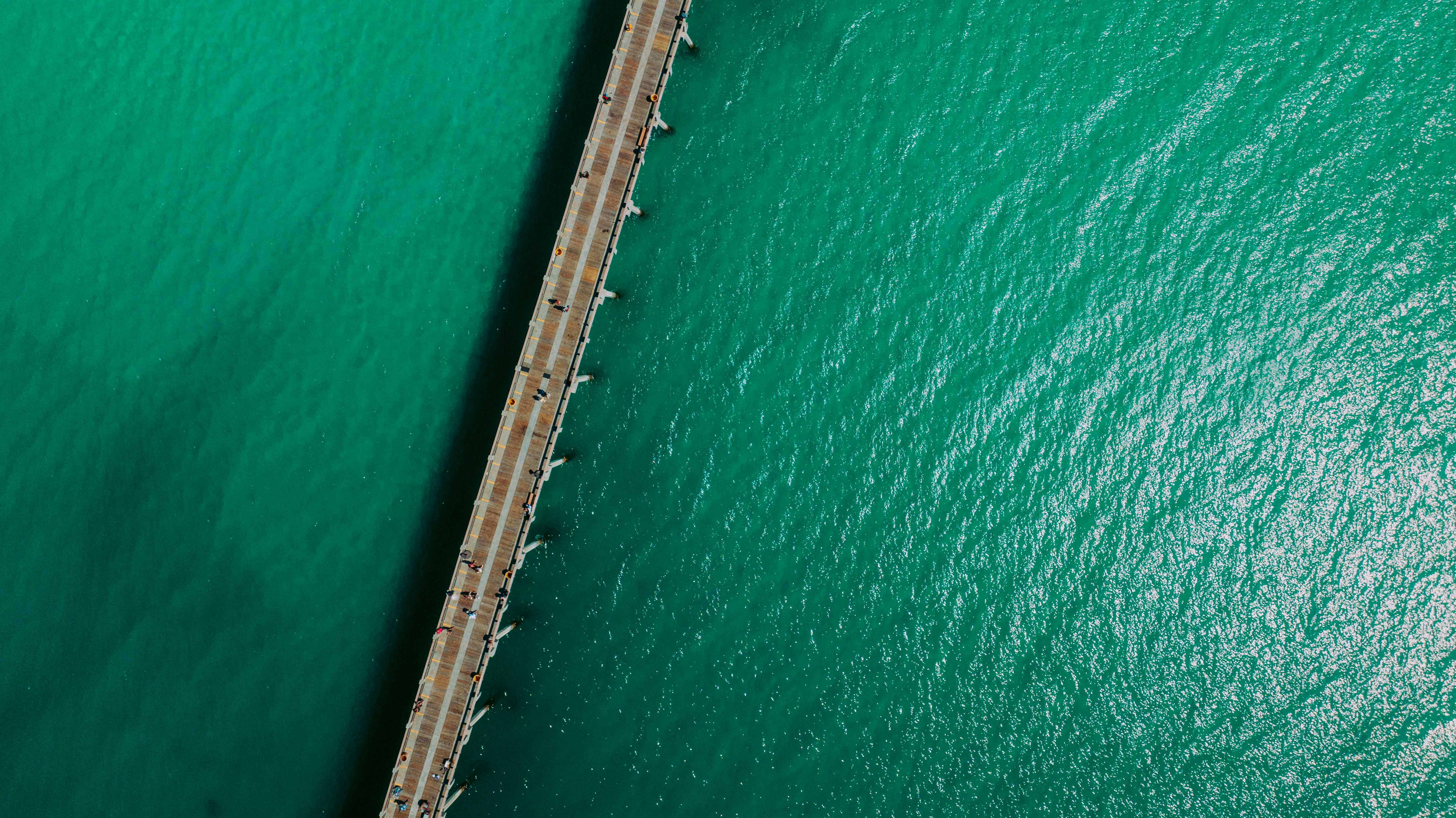 an aerial view of a bridge over a body of water, 