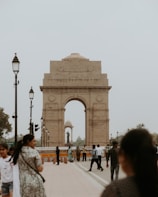 a group of people standing around a stone arch