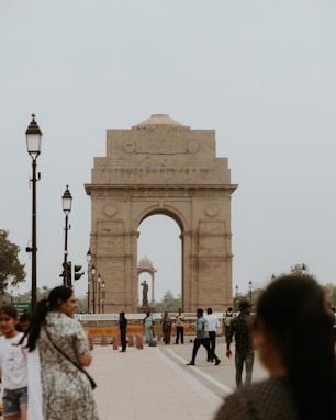 a group of people standing around a stone arch