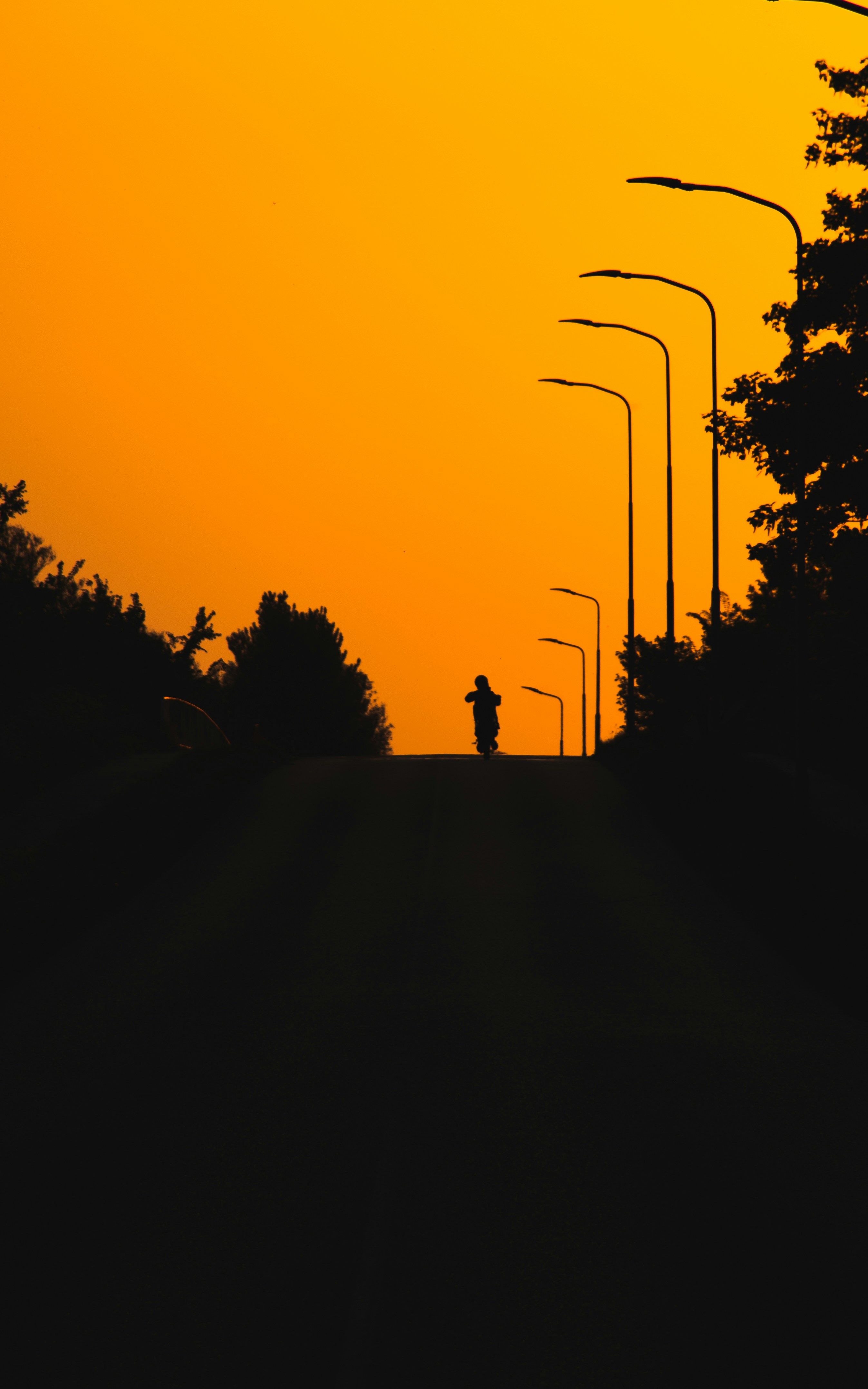 a person walking down a street at sunset