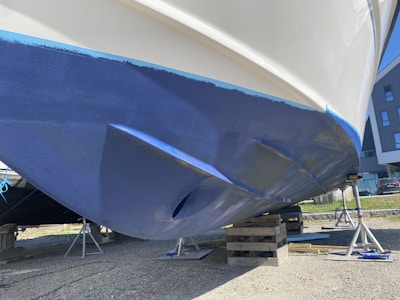 a blue and white boat being worked on