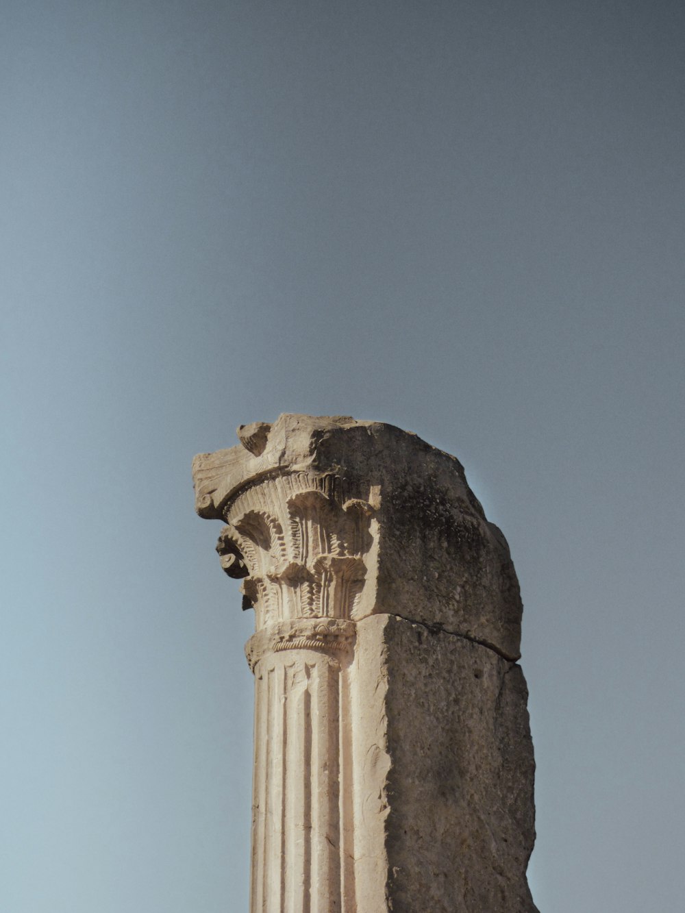 a tall stone pillar with a clock on top of it