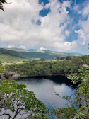 A serene nature photograph featuring deep blue waters and lush greenery.
