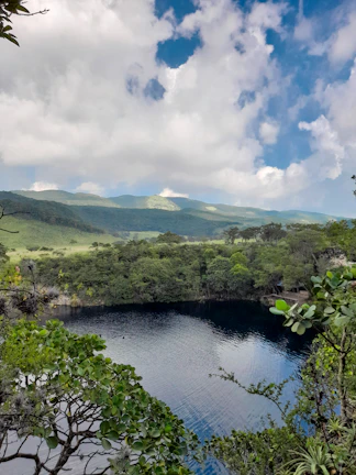 A serene nature photograph featuring deep blue waters and lush greenery.