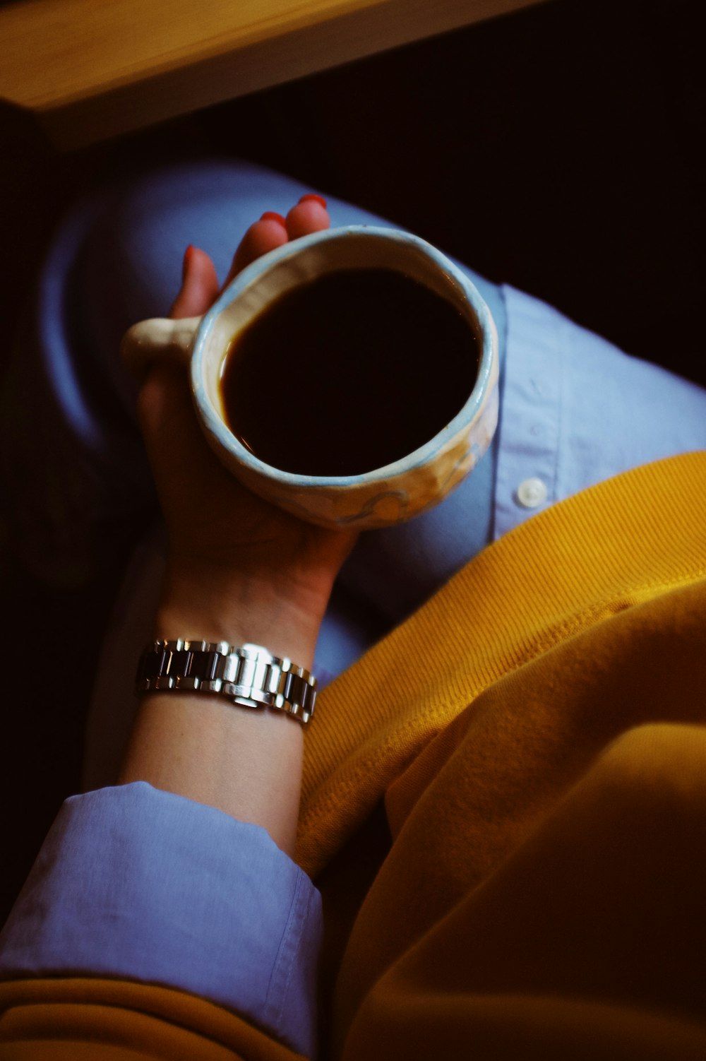 a person holding a cup of coffee in their hand