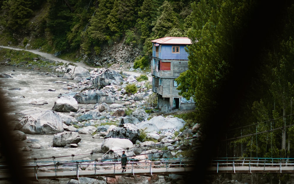 a blue house sitting on the side of a river