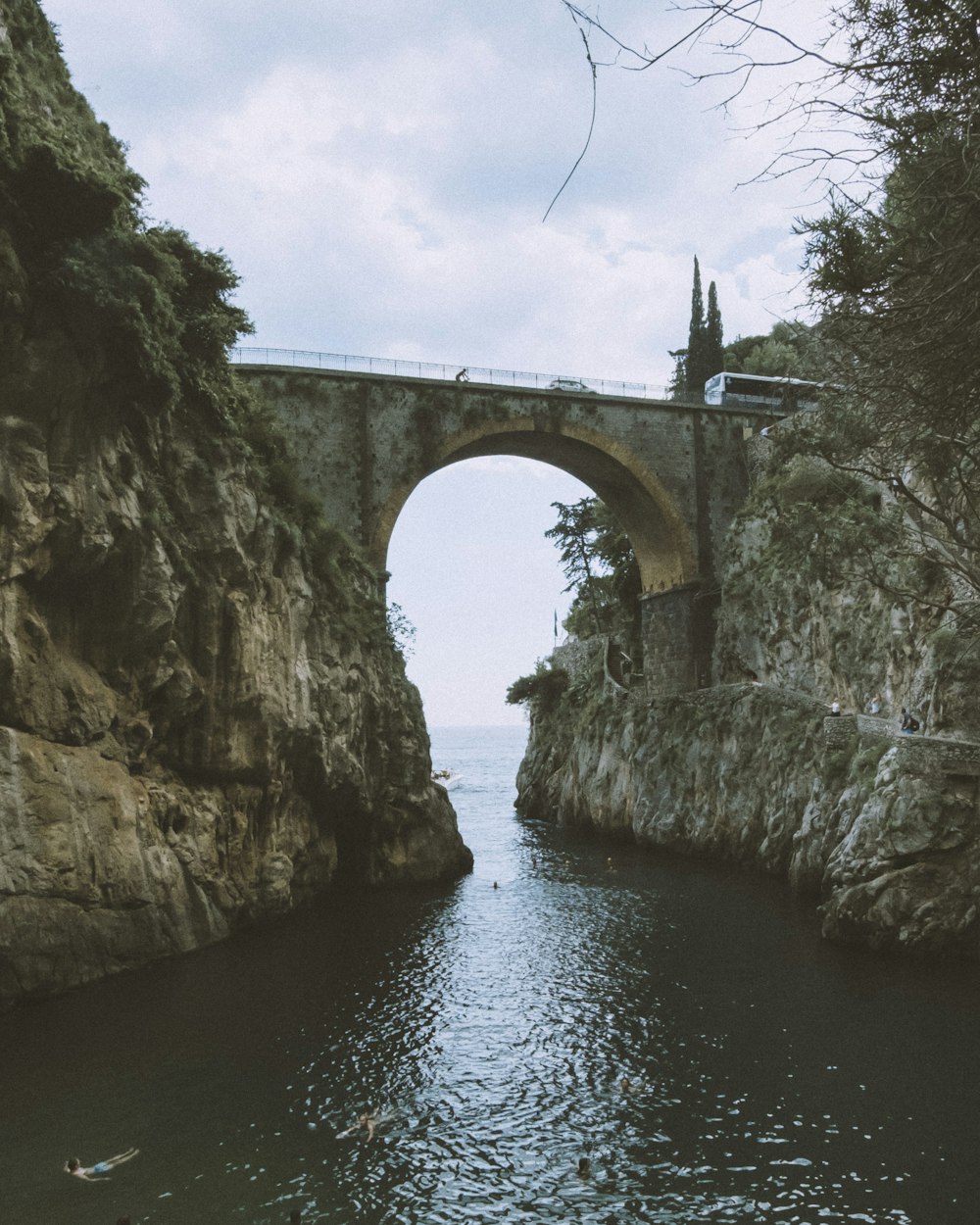 a bridge over a body of water next to a cliff