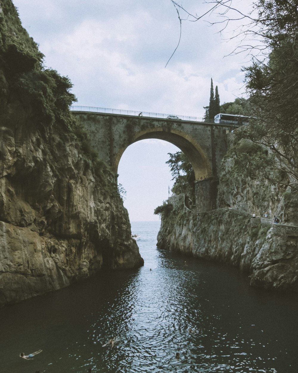 eine Brücke über ein Gewässer neben einer Klippe