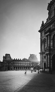A stark black-and-white photo of a courthouse facade, emphasizing its imposing columns and shadowed entrance.