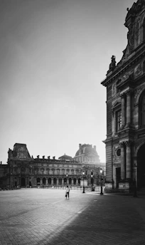 A stark black-and-white photo of a courthouse facade, emphasizing its imposing columns and shadowed entrance.