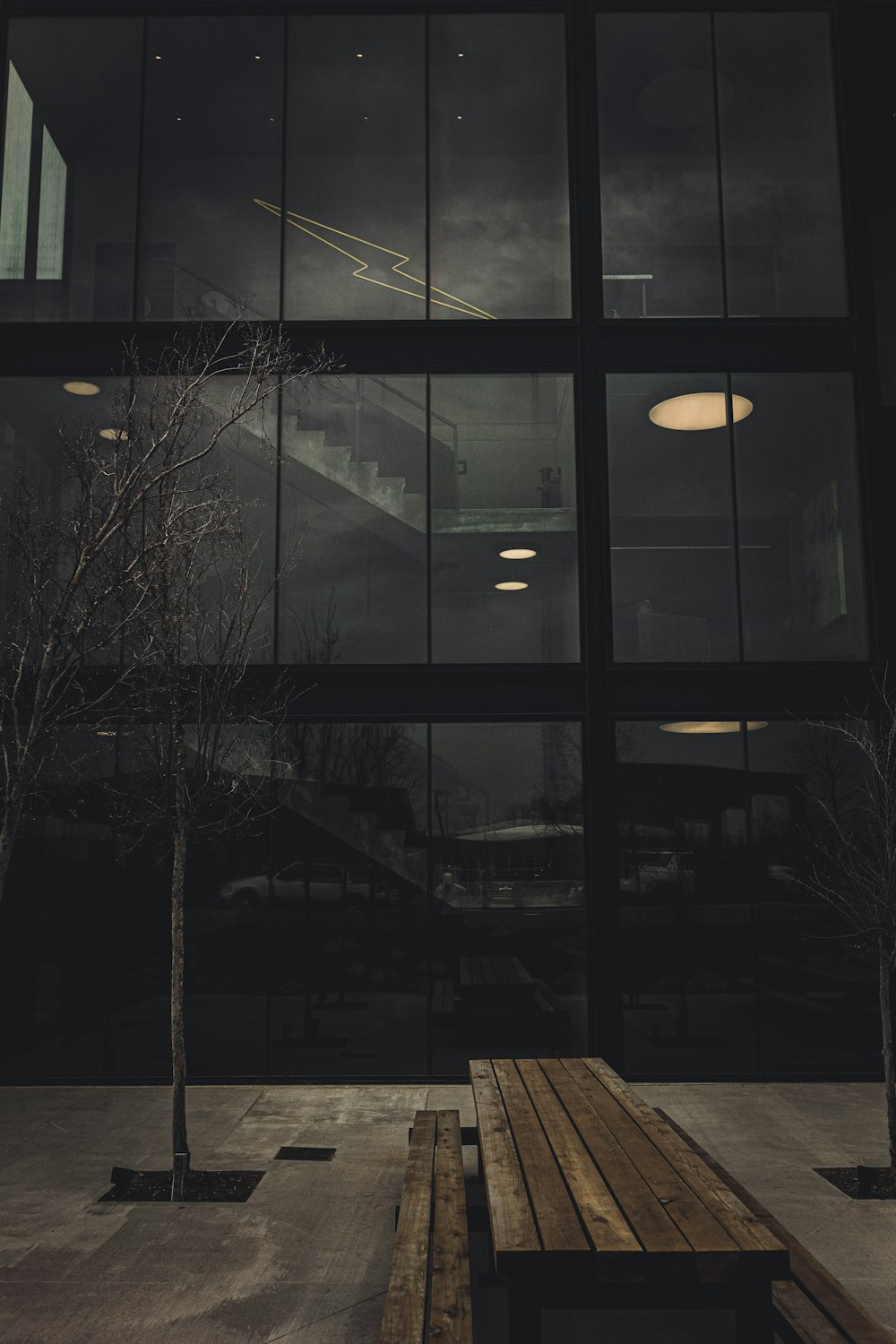 a wooden bench sitting in front of a large window