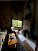 A rustic fireplace corner in a luxury cabin, with cozy armchairs and soft throws.