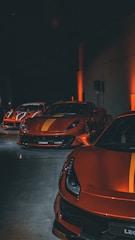 a row of sports cars parked in a parking lot