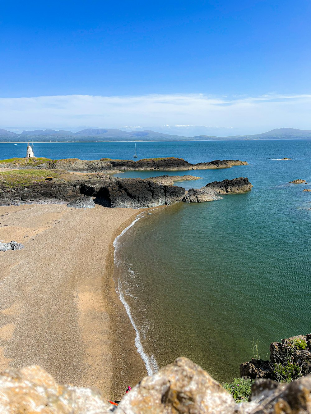 a view of a beach with a lighthouse in the distance