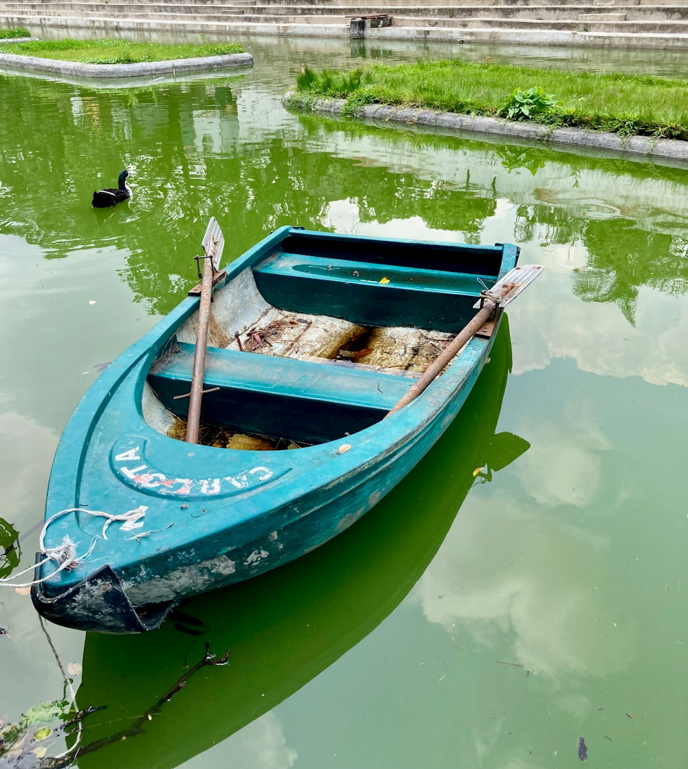 a small blue boat floating on top of a lake