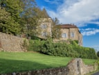 a stone house with a green lawn and a stone wall