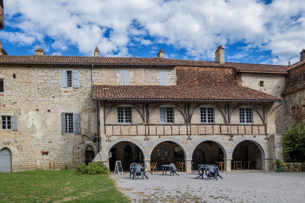 a large building with a courtyard and tables in front of it