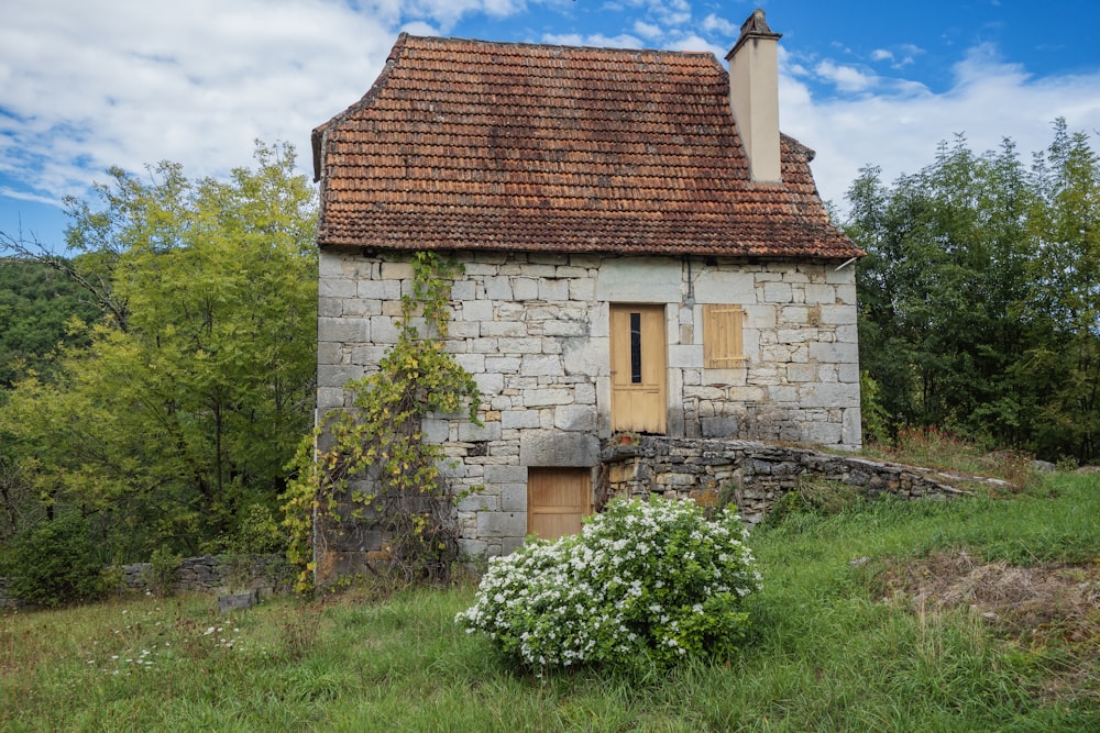 Una vecchia casa di pietra con un tetto rosso