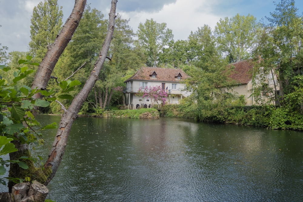 a large house sitting on the side of a river