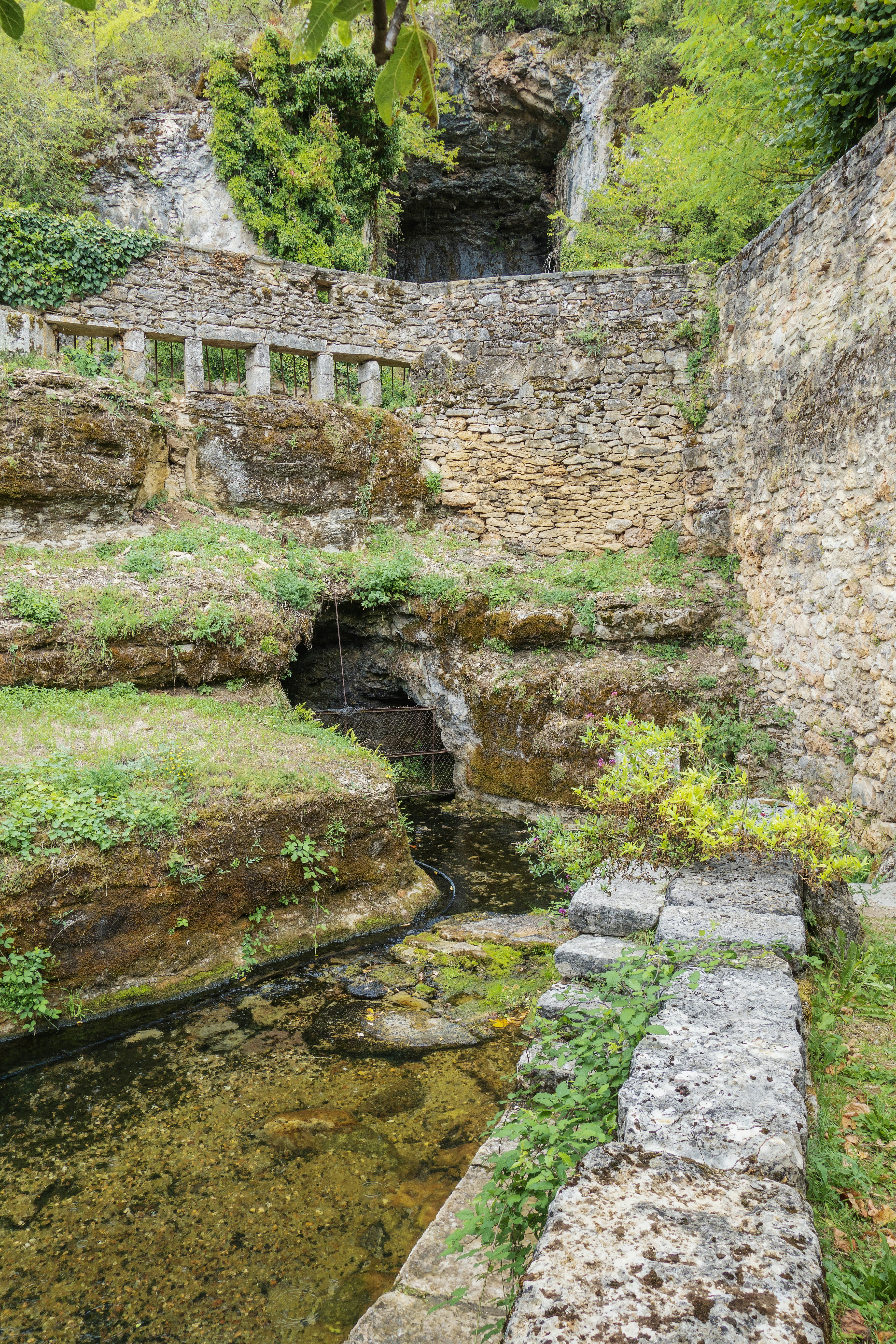 a stone bridge over a small stream in a park