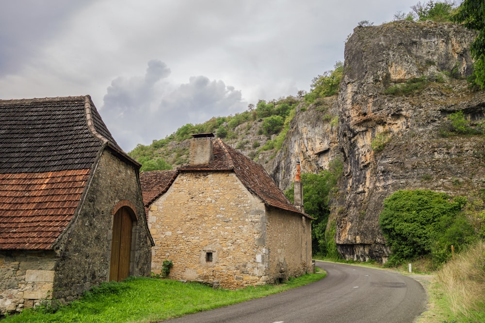 an old stone building sitting on the side of a road