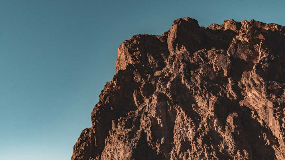 a tall mountain with a blue sky in the background