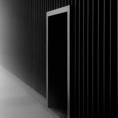 A sleek, minimalist architectural blueprint laid out on a dark textured surface.