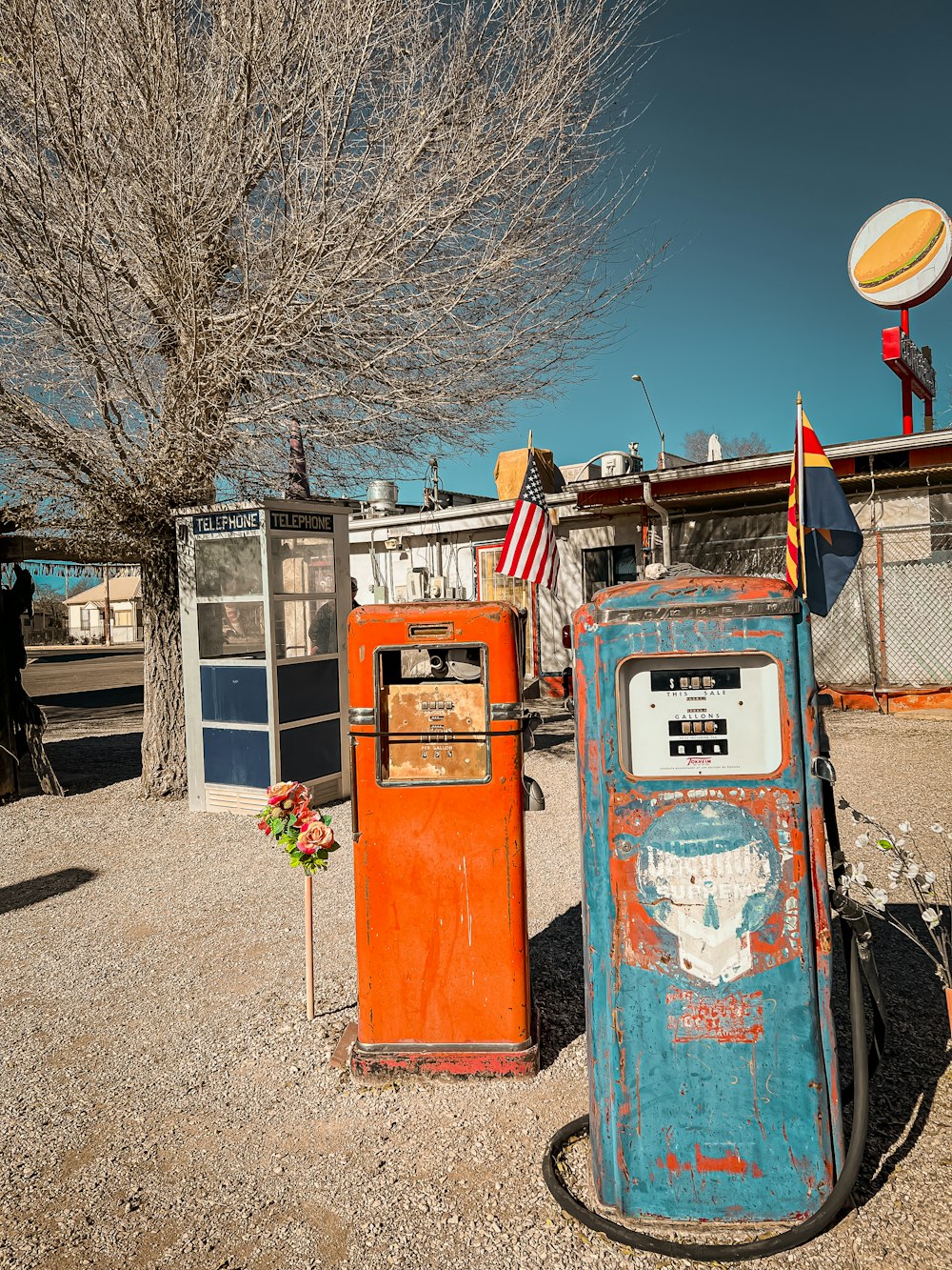 an old gas pump sitting next to a tree