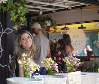 A smiling woman enjoying her freshly made juice at the Hamilton Farmer's Market stand.