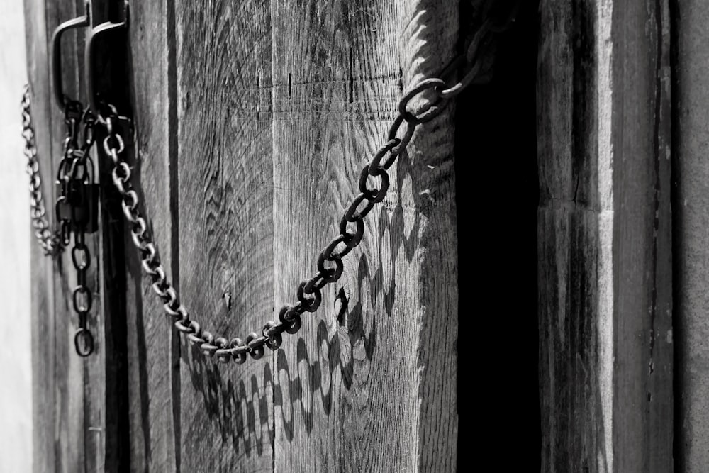 a black and white photo of a door with a chain on it