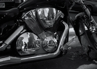 Close-up of a reflective motorcycle jacket sleeve catching the sunlight on a city street.