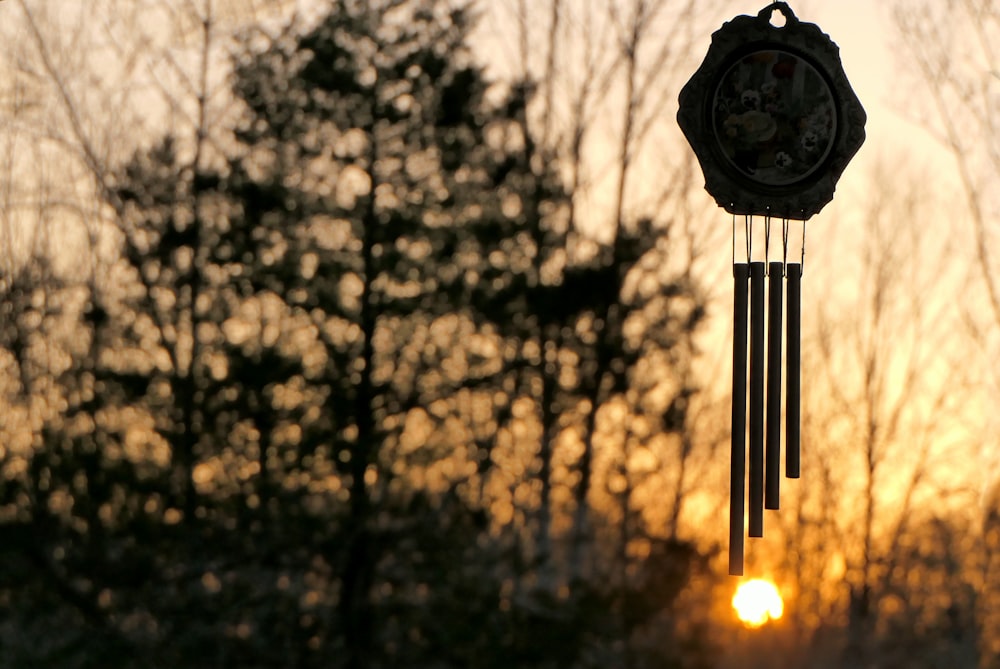 a wind chime with the sun setting in the background
