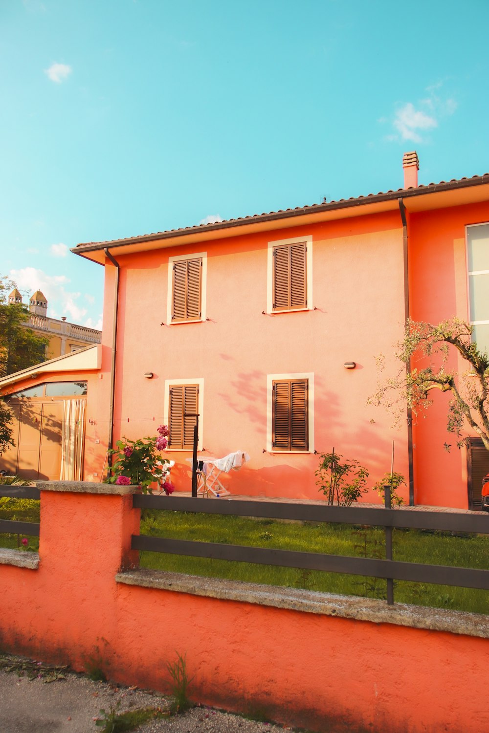 a pink house with a black fence in front of it