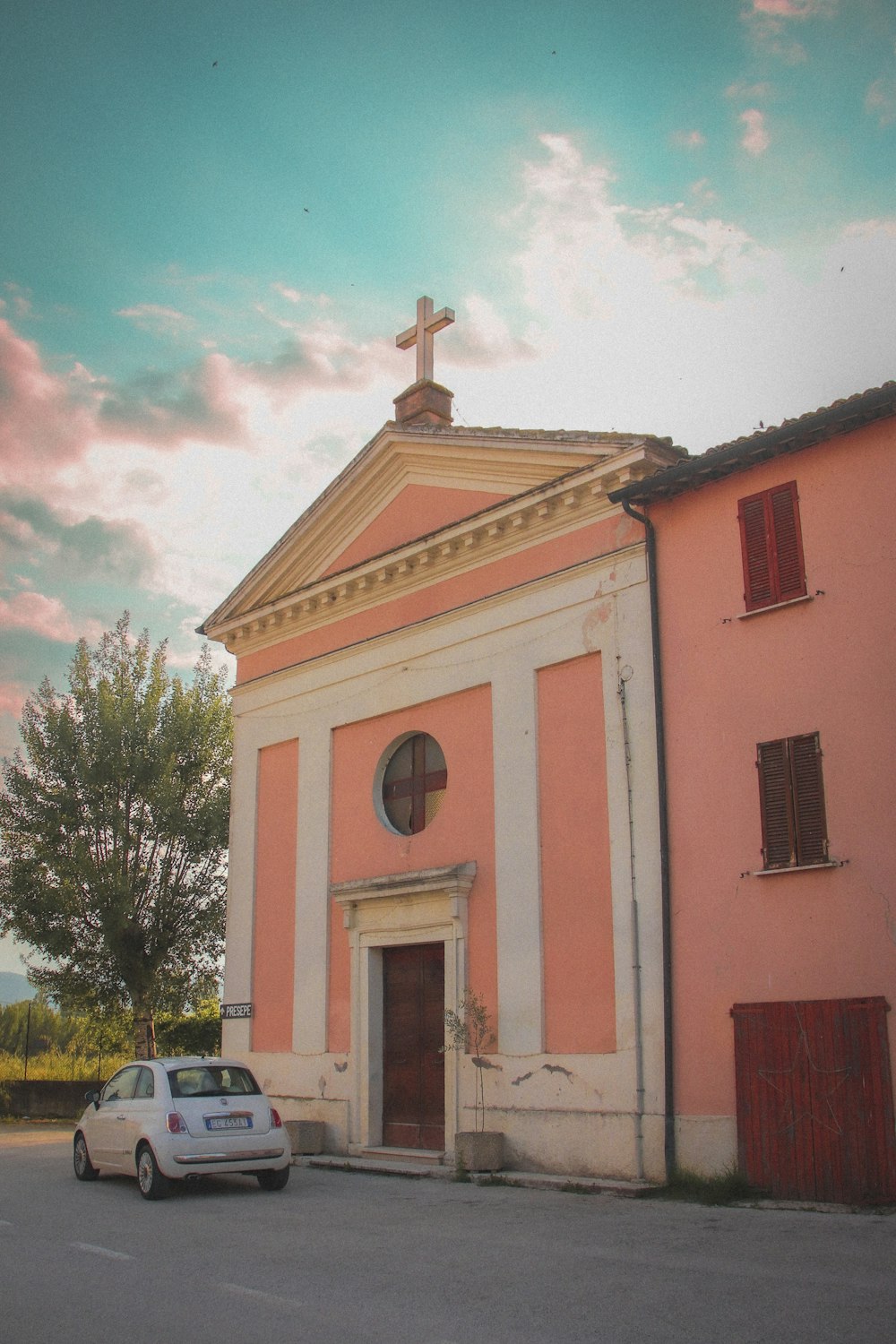 a car parked in front of a pink church