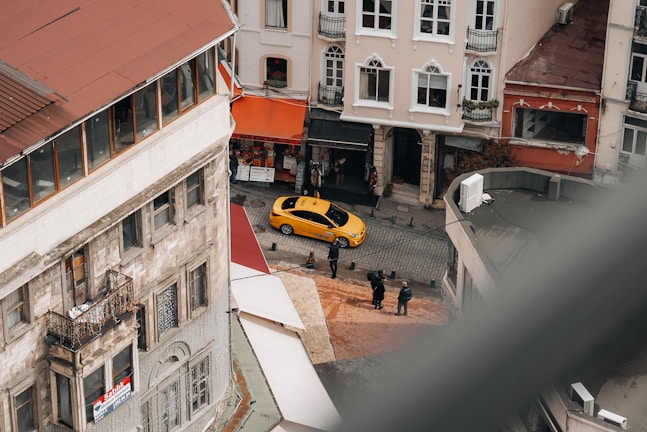 A vibrant street view of Itajaí-SC with a Tax Tolo taxi parked by the sidewalk.