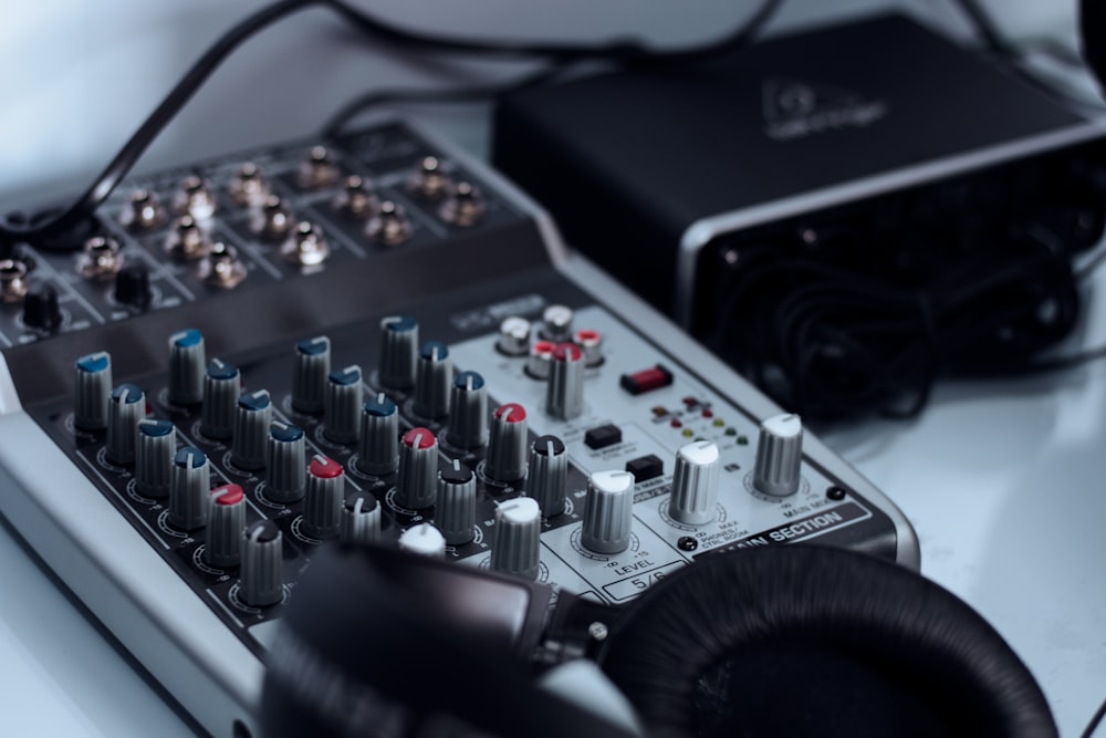 a sound mixing console with headphones on top of it