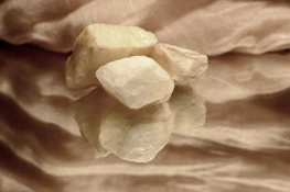 A serene photo of polished sphatic stones glowing softly in natural sunlight.