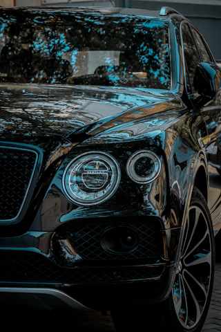 Experienced chauffeur greeting passengers with a warm smile beside a clean black SUV.