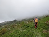 An influencer hiking through a misty mountain trail wearing branded outdoor gear.