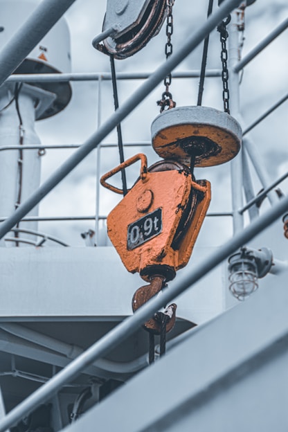 Close-up of heavy-duty industrial lifting straps with metal hooks and ratchets