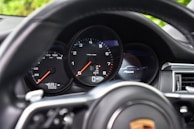 Close-up of the Porsche 911 dashboard showing custom options and mileage.