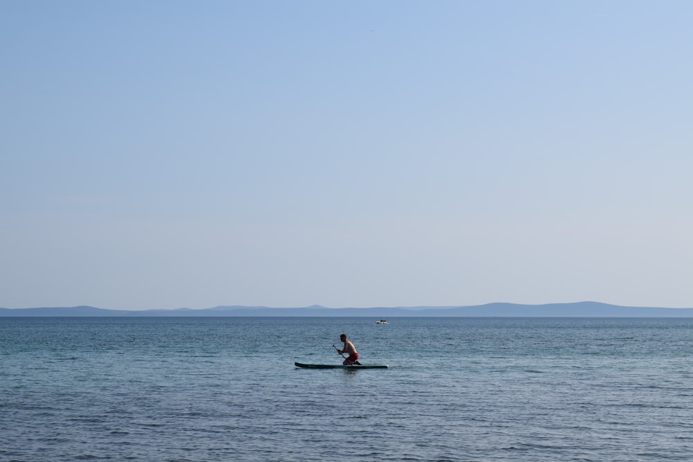 a person in a boat in the middle of the ocean