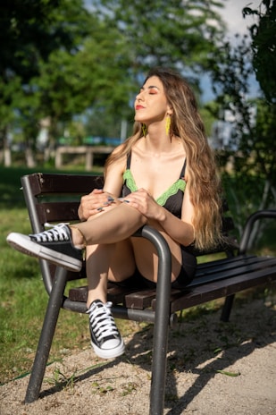 A woman wearing a stylish summer top and shorts, enjoying a sunny day in a park.