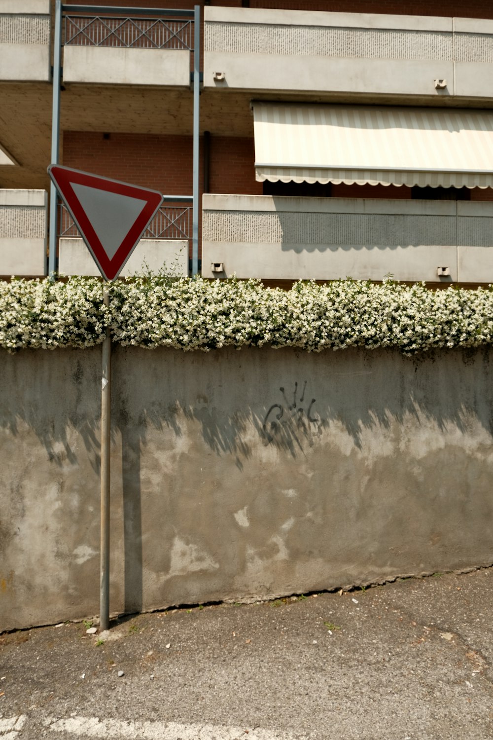 a red and white street sign sitting on the side of a wall