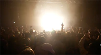 Close-up of excited faces enjoying a live show in a black-themed venue.